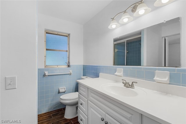 bathroom with vanity, a shower, toilet, tile walls, and wood-type flooring