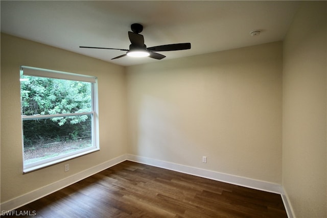 spare room with dark hardwood / wood-style floors, a wealth of natural light, and ceiling fan