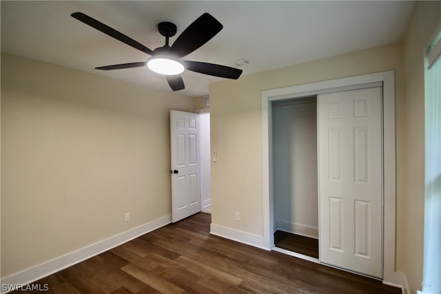 unfurnished bedroom with dark hardwood / wood-style floors, a closet, and ceiling fan