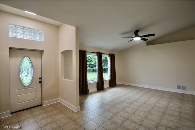 tiled foyer entrance with ceiling fan and vaulted ceiling