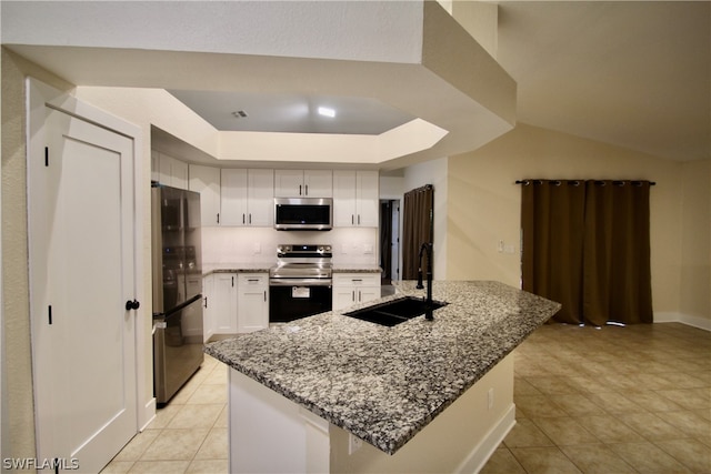 kitchen featuring white cabinetry, light tile patterned flooring, a tray ceiling, sink, and appliances with stainless steel finishes