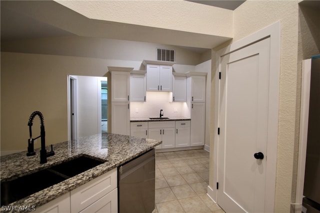 kitchen with sink, dark stone countertops, dishwasher, and white cabinets