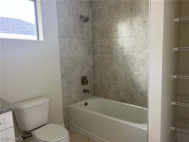 full bathroom featuring tiled shower / bath, vanity, toilet, and tile patterned floors