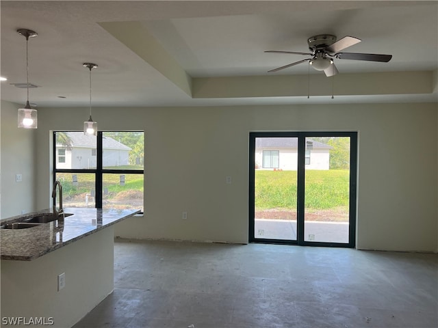 unfurnished room featuring ceiling fan, plenty of natural light, and sink