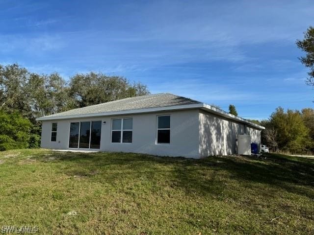 rear view of house featuring a lawn