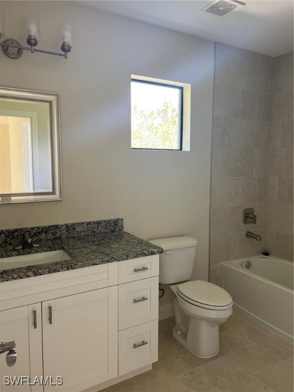 full bathroom with tiled shower / bath combo, vanity, toilet, and tile patterned floors