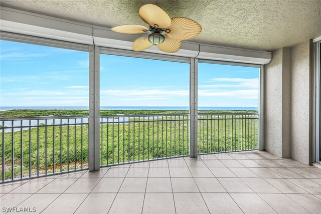 unfurnished sunroom featuring ceiling fan