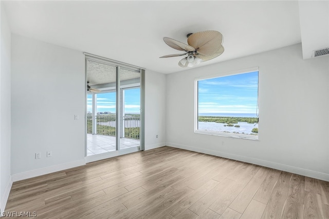 spare room featuring light hardwood / wood-style flooring and ceiling fan