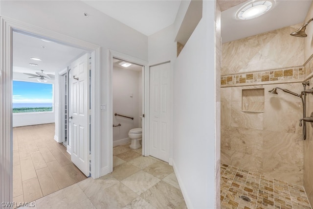 bathroom featuring ceiling fan, a tile shower, and toilet