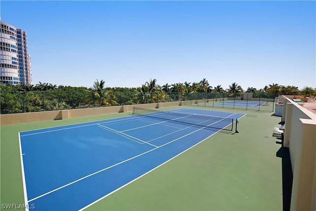 view of tennis court featuring fence