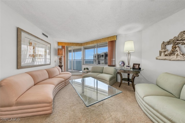 living room with carpet, visible vents, and a textured ceiling