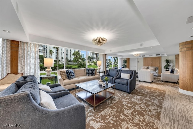 living area featuring a tray ceiling and wood finished floors