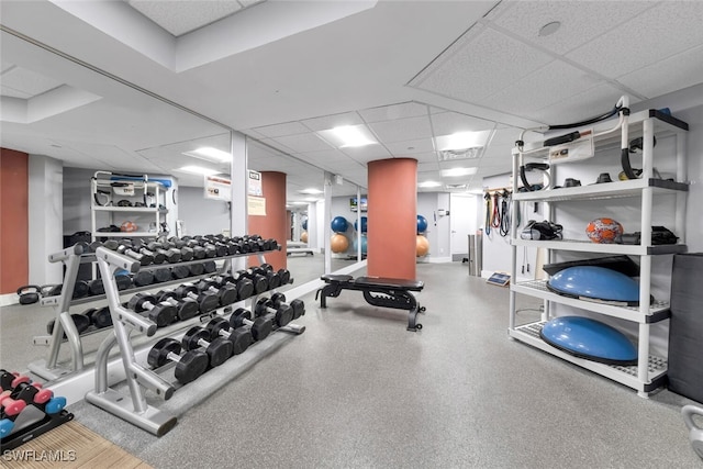 exercise room with baseboards and a drop ceiling