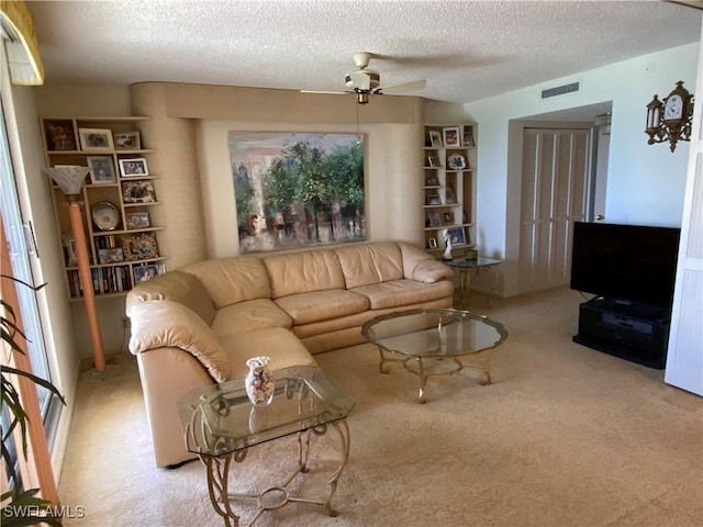 carpeted living area featuring a ceiling fan, visible vents, and a textured ceiling