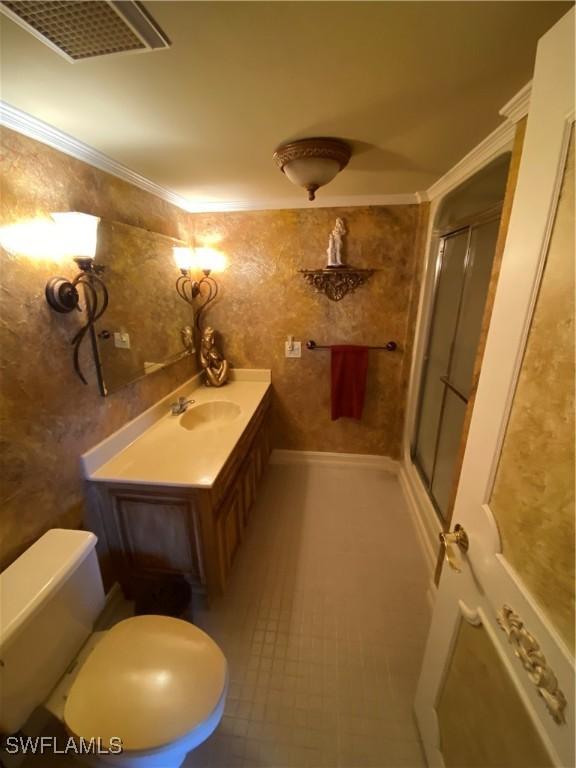 full bathroom featuring toilet, visible vents, vanity, a stall shower, and crown molding