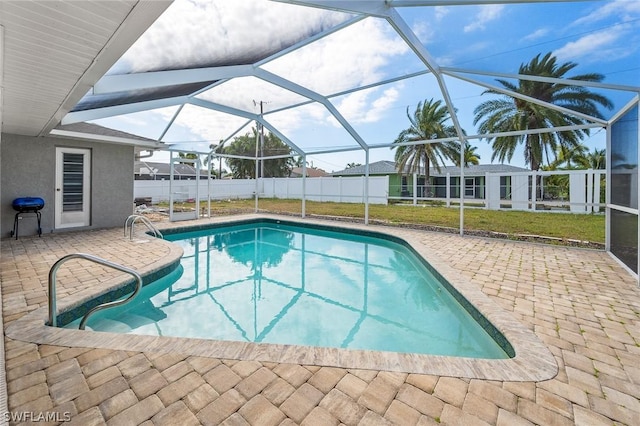 view of pool featuring a lawn, area for grilling, a patio area, and a lanai