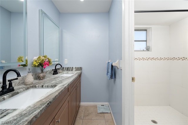 bathroom with tile patterned floors, vanity, and tiled shower