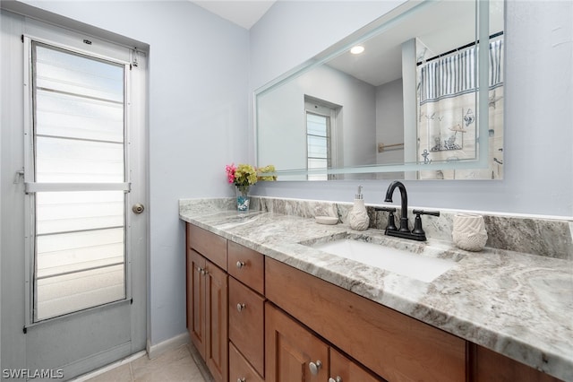 bathroom with tile patterned flooring, vanity, and plenty of natural light