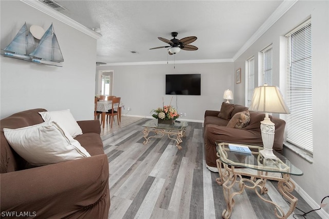 living room with ceiling fan, ornamental molding, a wealth of natural light, and light hardwood / wood-style flooring