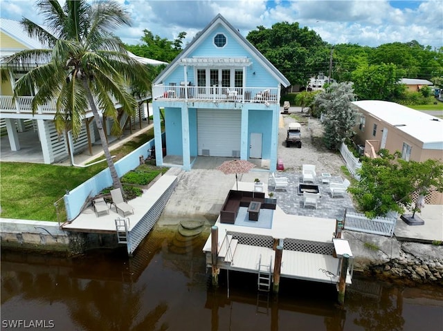 rear view of house with a patio area and a water view