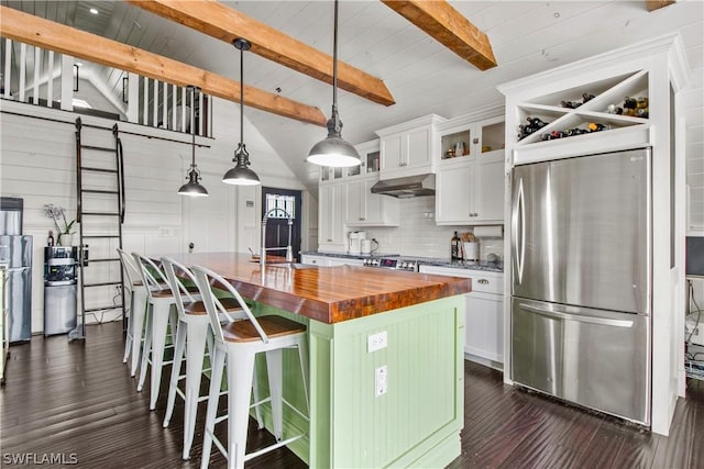 kitchen featuring white cabinetry, a kitchen island with sink, stainless steel refrigerator, and hanging light fixtures