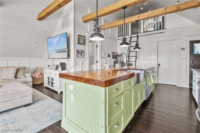 kitchen featuring butcher block counters, an island with sink, pendant lighting, sink, and green cabinetry