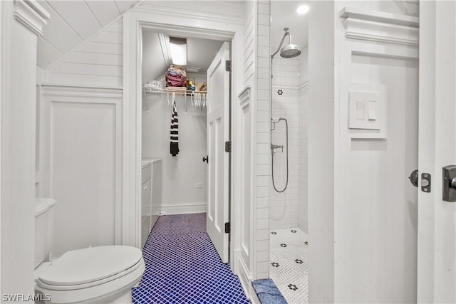 bathroom featuring tiled shower and toilet