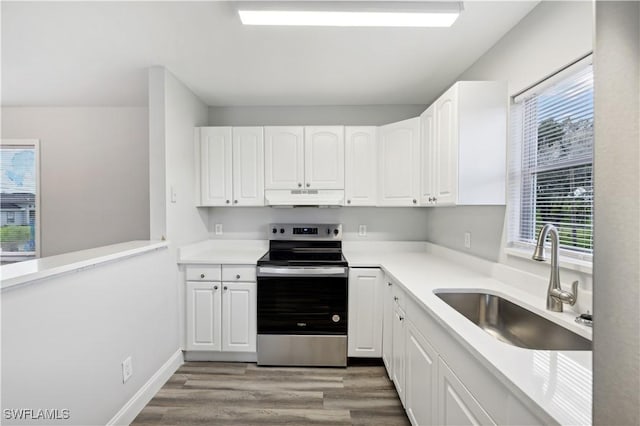 kitchen with white cabinets, plenty of natural light, stainless steel electric range oven, and sink