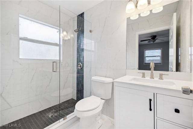 bathroom featuring ceiling fan, vanity, a shower with shower door, and toilet