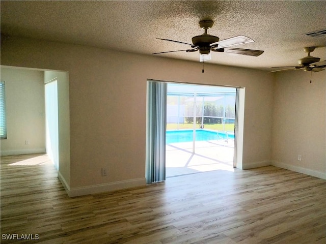 spare room featuring a textured ceiling, hardwood / wood-style flooring, and ceiling fan