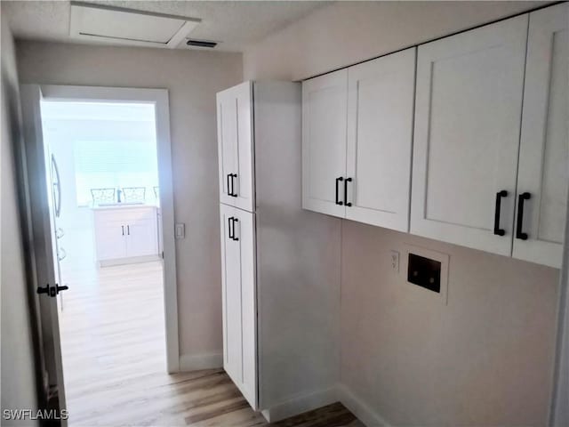 laundry room featuring cabinets, hookup for a washing machine, and light wood-type flooring