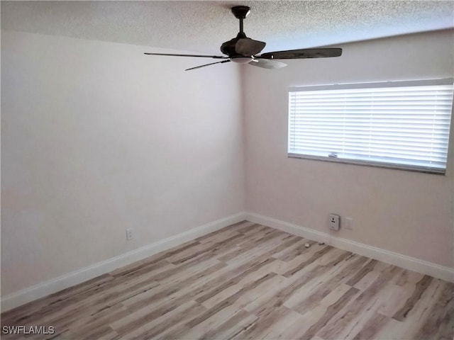 spare room with a textured ceiling, light wood-type flooring, and ceiling fan