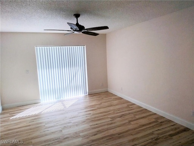 empty room featuring a textured ceiling, light hardwood / wood-style floors, and ceiling fan