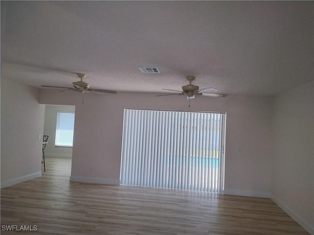 empty room with light hardwood / wood-style floors and a textured ceiling