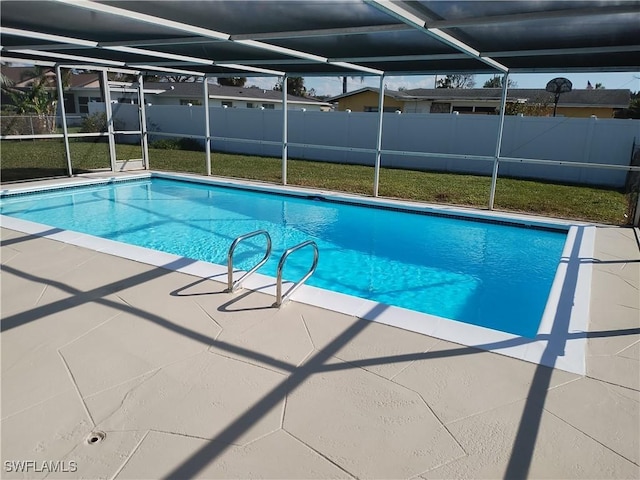 view of swimming pool featuring a patio area and a lanai