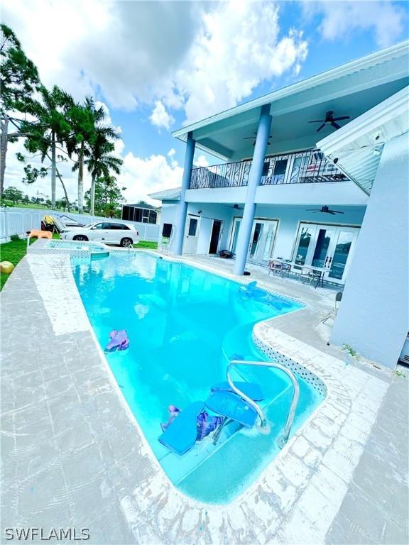 view of swimming pool featuring ceiling fan and a patio