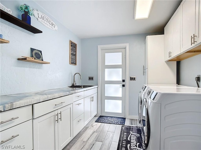 laundry room with cabinets, sink, and washer and dryer