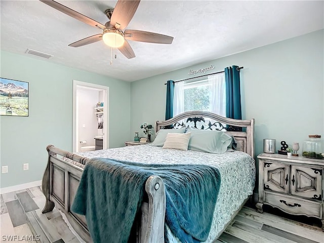 bedroom with ceiling fan, connected bathroom, and light hardwood / wood-style floors