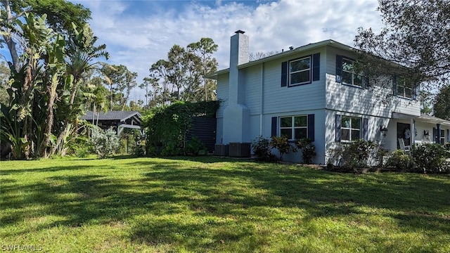 view of property exterior with central AC unit and a yard