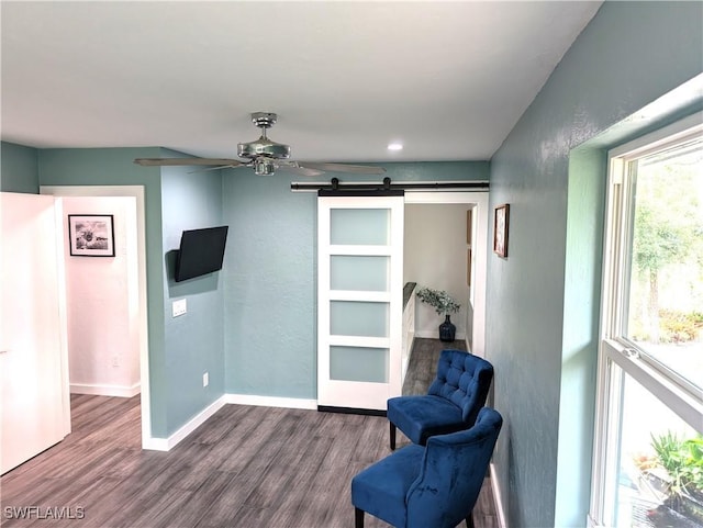 15711 Anderson Ln, Fort Myers, FL 33912 - sitting room featuring a barn door, dark wood-type flooring, ceiling fan, baseboards, and a textured wall