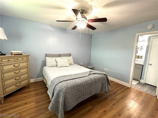 bedroom with ceiling fan, ensuite bath, and hardwood / wood-style flooring