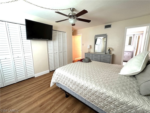 bedroom featuring ceiling fan, wood-type flooring, and multiple closets