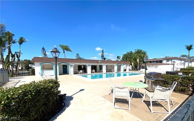 view of swimming pool with grilling area and a patio