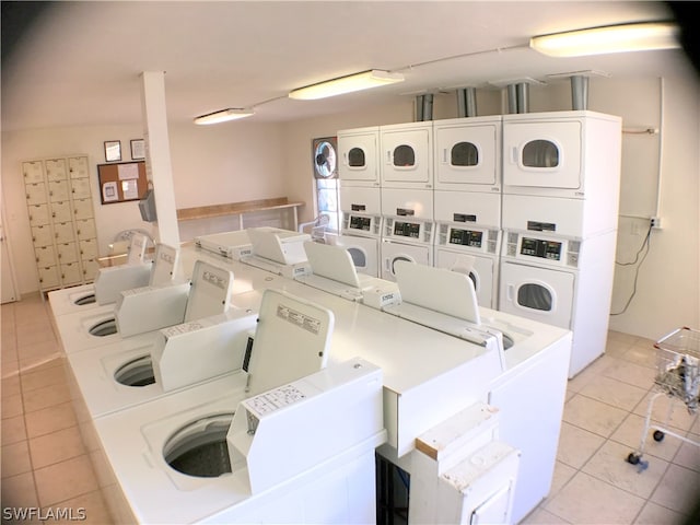 laundry room featuring light tile patterned floors, washer and clothes dryer, and stacked washer and dryer