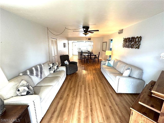 living room featuring light hardwood / wood-style flooring and ceiling fan