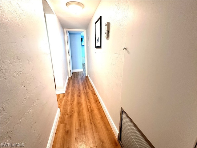 hallway with hardwood / wood-style floors