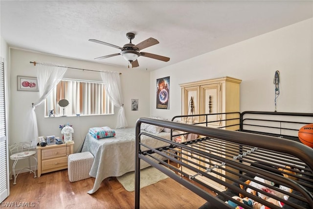 bedroom with ceiling fan, a textured ceiling, and wood-type flooring