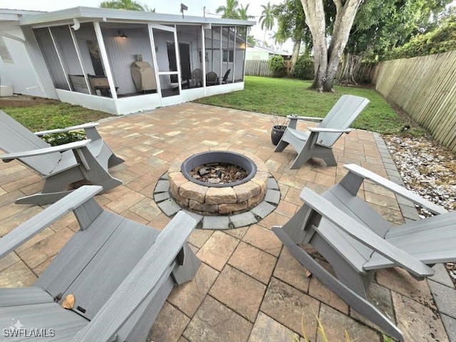 view of patio / terrace with a sunroom and a fire pit