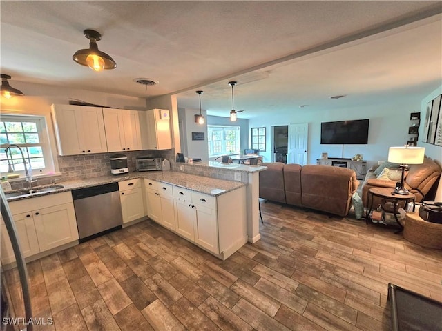 kitchen with hanging light fixtures, dishwasher, white cabinets, and kitchen peninsula