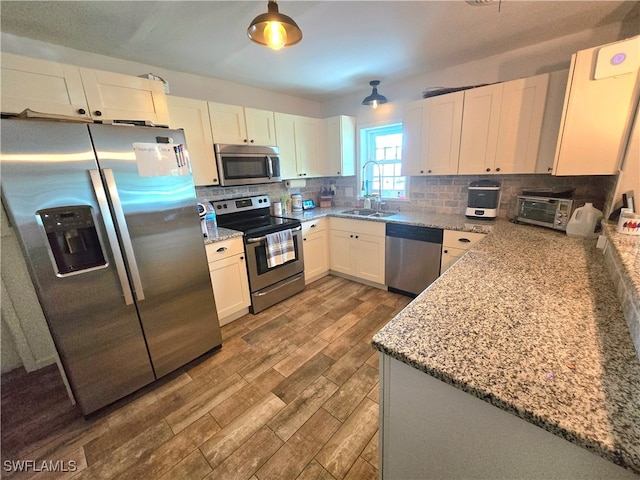 kitchen with sink, decorative backsplash, appliances with stainless steel finishes, and hardwood / wood-style floors